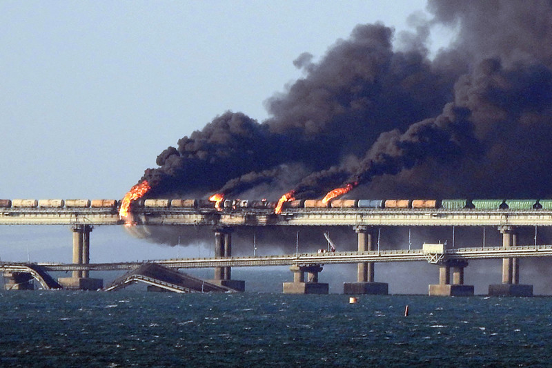  TOPSHOT - Black smoke billows from a fire on the Kerch bridge that links Crimea to Russia, after a truck exploded, near Kerch, on October 8, 2022. - Moscow announced on October 8, 2022 that a truck exploded igniting a huge fire and damaging the key Kerch bridge -- built as Russia's sole land link with annexed Crimea -- and vowed to find the perpetrators, without immediately blaming Ukraine. (Photo by AFP)