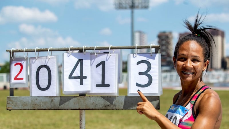 Ana Cláudia da Silva aponta para placa com recorde mundial no salto em distância no CT Paralímpico