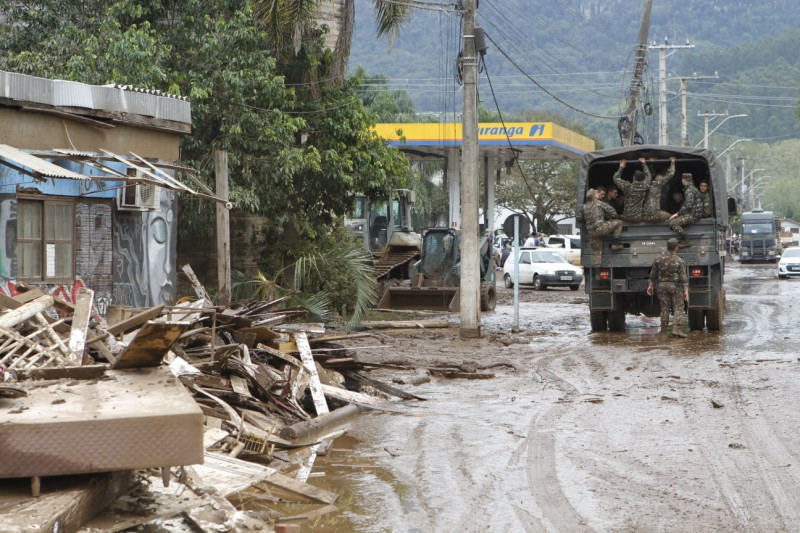 Caminhão do Exército passa por rua cheia de lama após enchente na cidade de Muçum