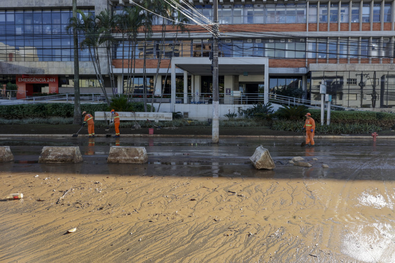 Funcionários da prefeitura retiravam o lodo que ficou após a drenagem da água nesta manhã