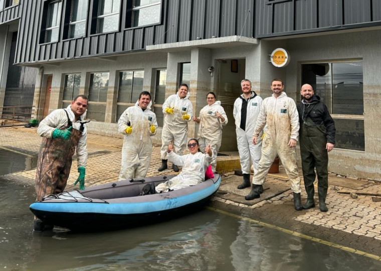 Scheid e equipe em frente à fábrica na Zona Norte: acesso feito com bote devido à inundação