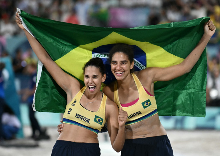  Brazil's #02 Eduarda Santos Lisboa and Brazil's #01 Ana Patricia Silva Ramos celebrate after winning the women's gold medal beach volleyball match between Brazil and Canada during the Paris 2024 Olympic Games at the Eiffel Tower Stadium in Paris on August 9, 2024. (Photo by CARL DE SOUZA / AFP)